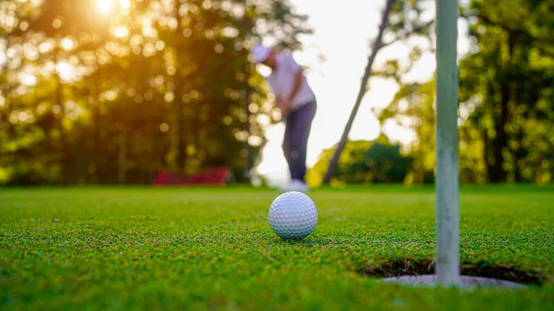 Close up view of golf ball going into hole