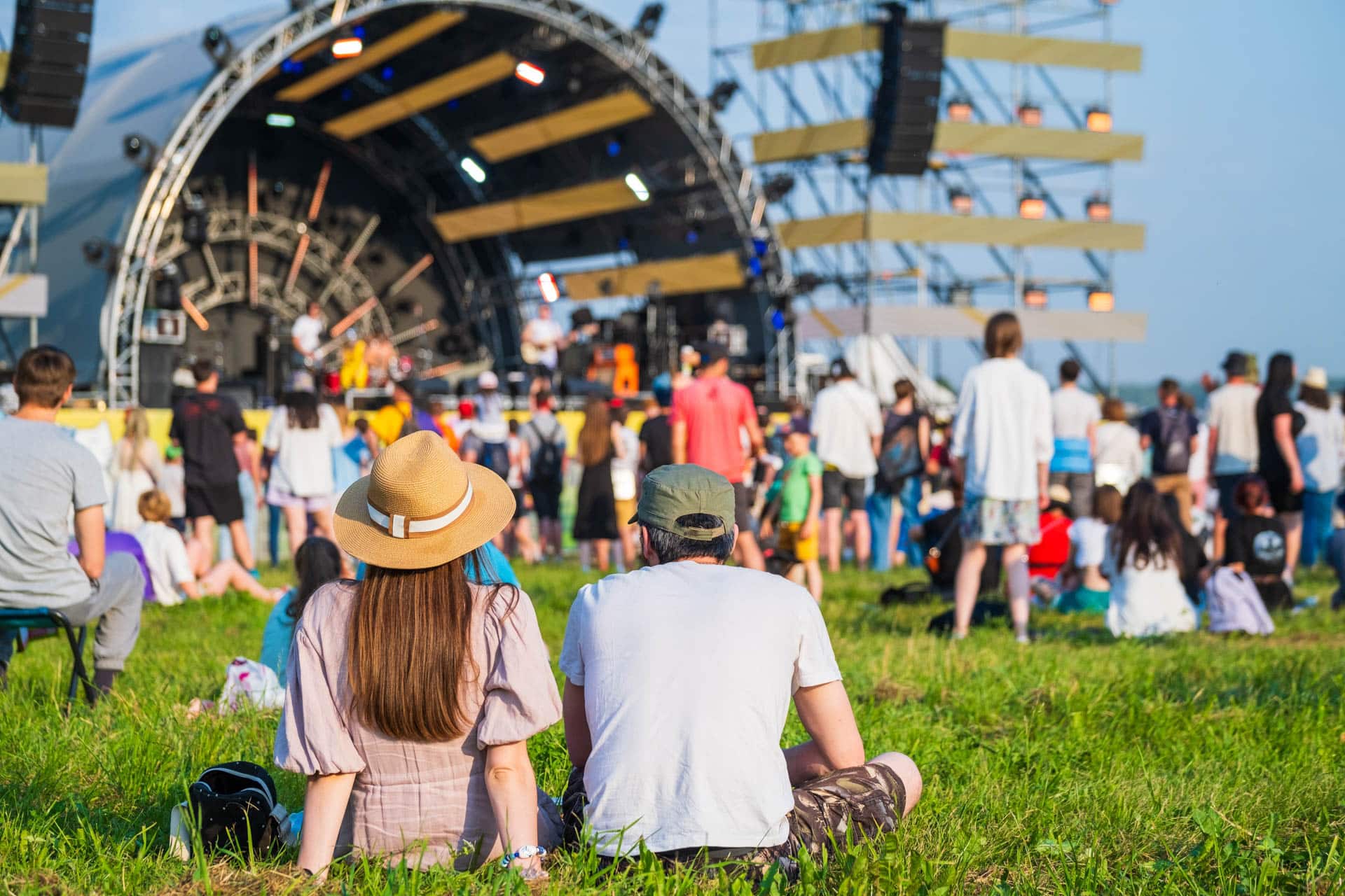 Couple sitting down watching concert sunny day