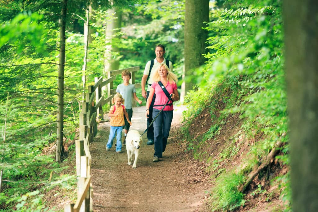 Family hiking with dog on leash