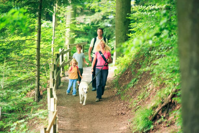 Family hiking with dog on leash