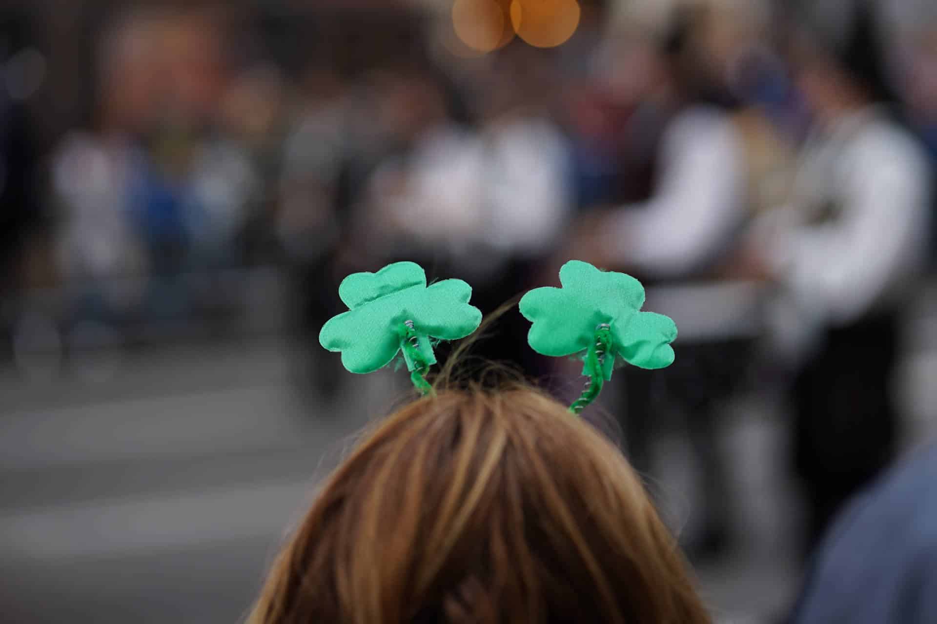 Young child wearing a shamrock headband watching the St.Patricks Day parade