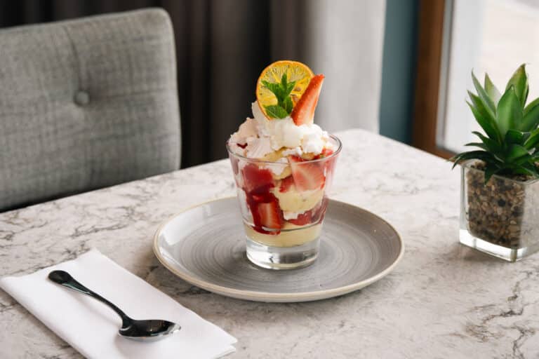Ice cream sundae topped with strawberries and wafer