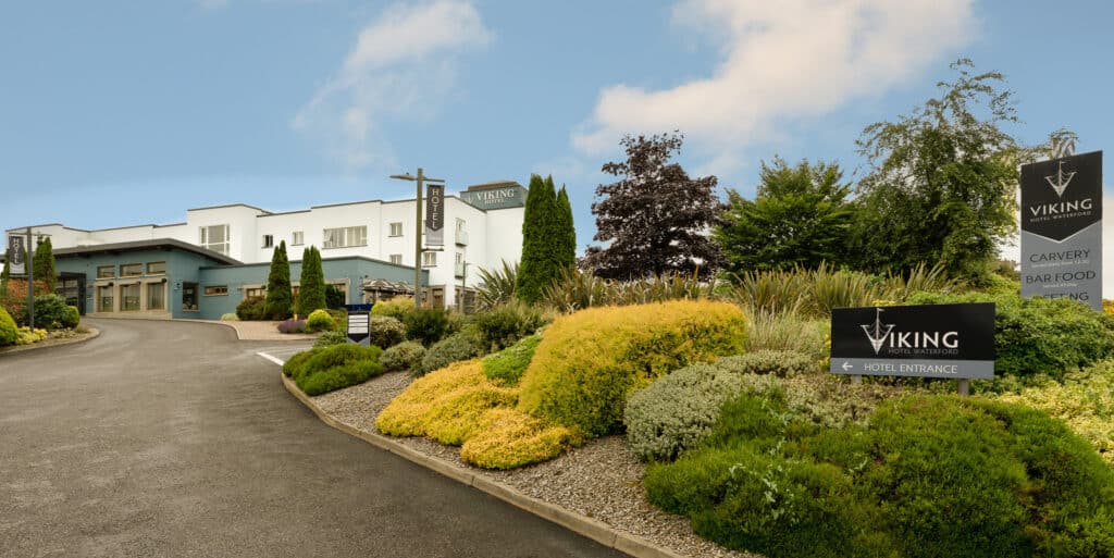 Exterior of Viking Hotel Waterford surrounded by neatly trimmed landscaping and blue skies