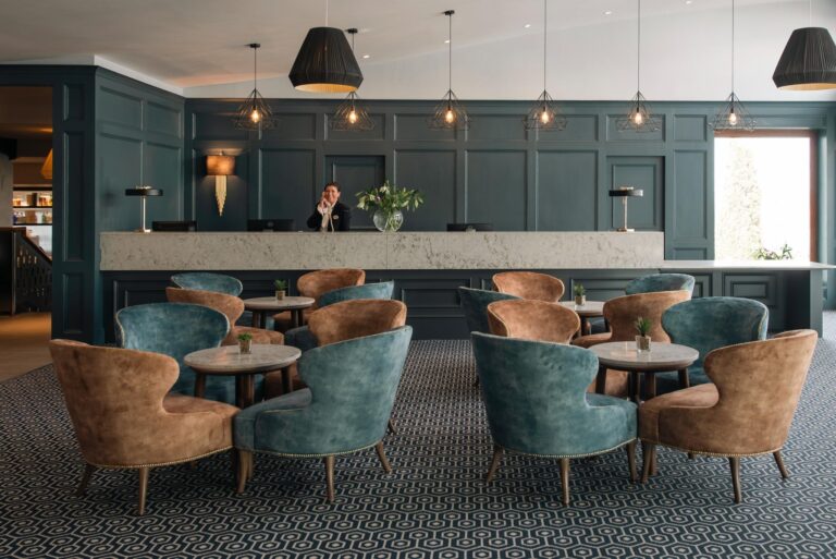 Wide view of Viking Hotel lobby seating area with teal and brown chairs facing the reception desk.